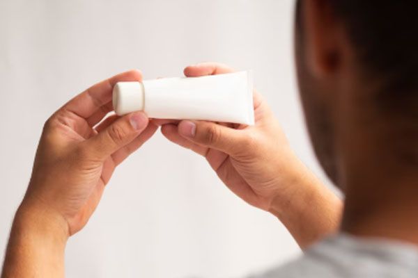 Avvicinarsi alle mani che tengono un tubo di crema