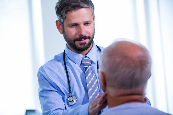 un giovane medico esamina un paziente anziano calvo - trapianto capelli milano costi