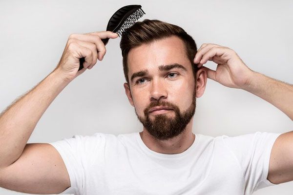 Ripresa frontale di un uomo che si pettina i capelli