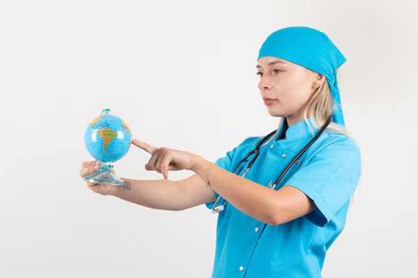 dottoressa in uniforme blu che mette il dito su un mappamondo - trapianto di capelli in Italia o all’estero