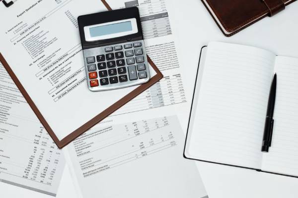 Calcolatrice e documenti utilizzati per confrontare rata, interessi e costo complessivo di un finanziamento